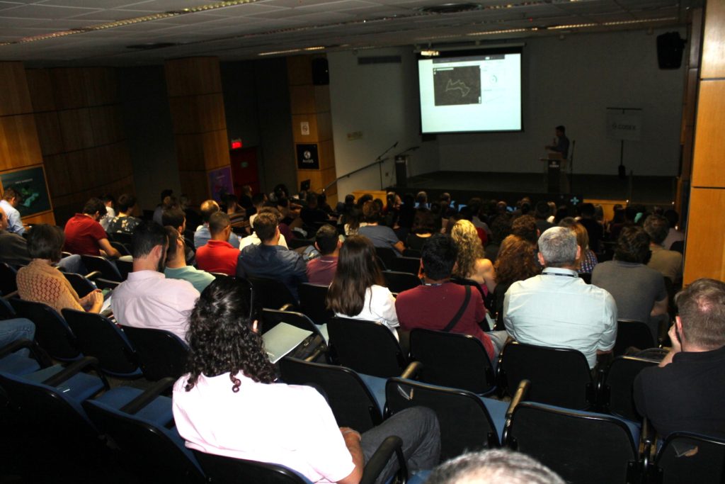 Registro dos participantes assistindo ao Seminário Esri Sul 2019, com Gustavo Gontijo ao fundo.