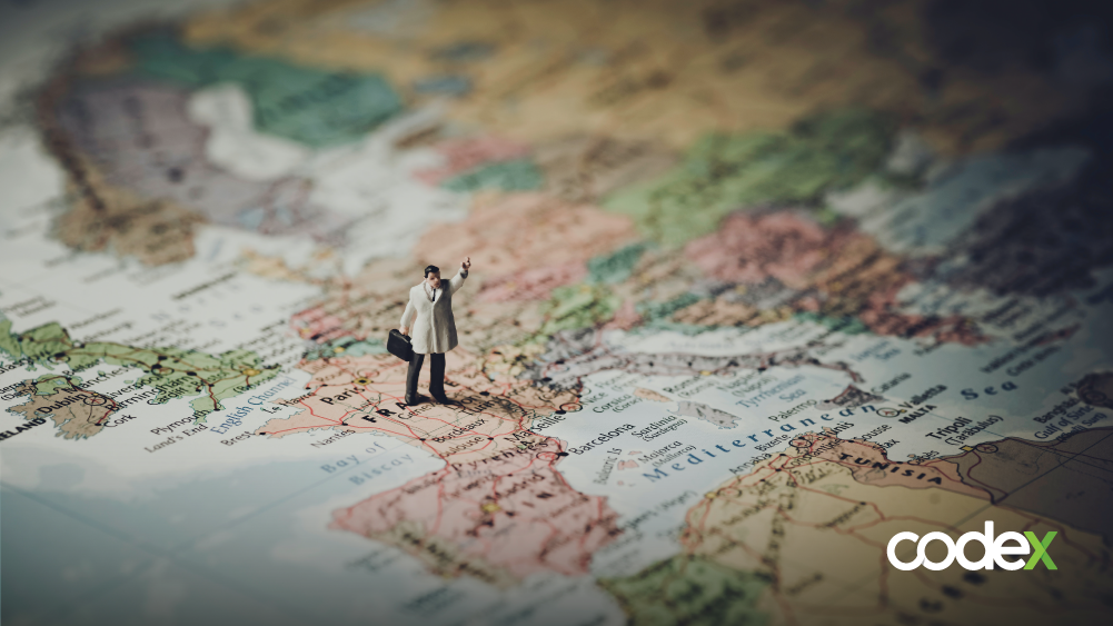 Foto de um boneco em cima de um mapa, em pé na área do continente europeu.